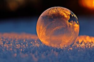 pexels photo 302743 302743 Close-up shot of a frozen bubble with warm reflections resting on a snowy surface at twilight.